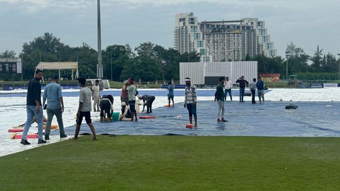 Workers at the Shaheed Vijay Singh Pathik Sports Complex in Greater Noida, trying to dry the outfield | Photo: Sagrika Kissu, ThePrint