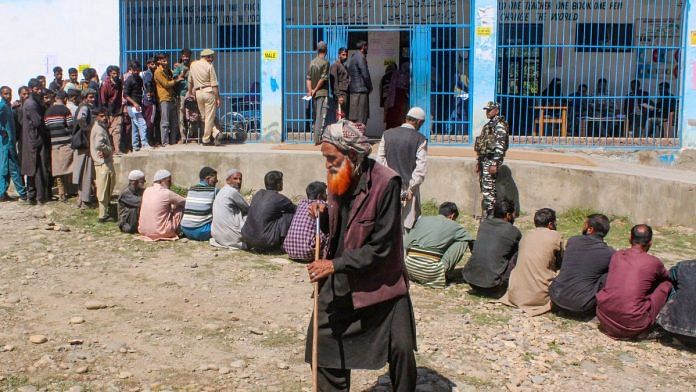 Voters wait in a queue at a polling station during the first phase of Assembly elections, in Shopian district of south Kashmir, Wednesday | PTI Photo