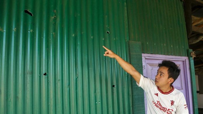 Mairembam Kelvin shows the holes in the tin shed in the compound of his late grandfather's house after a rocket bomb attack in Moirang, Manipur | Suraj Singh Bisht | ThePrint