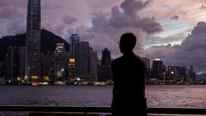 A man stands in front of Victoria Harbour, with the Central financial district in the background, as typhoon Yagi approaches in Hong Kong, China 5 September 2024 | Reuters/Tyrone Siu