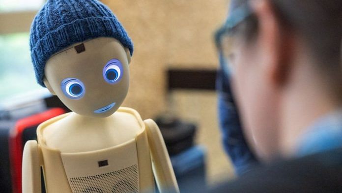 A visitor talks with the Navel robot, by Navel Robotics, during the AI for Good Global summit on artificial intelligence, organised by the International Telecommunication Union (ITU), in Geneva | REUTERS/Denis Balibouse/File photo