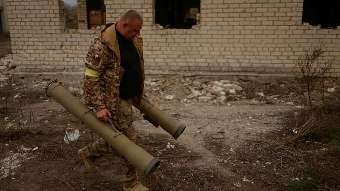 A Ukrainian serviceman carries captured anti-tank grenade launchers at a former position of Russian soldiers in the village of Blahodatne in Kherson region, Ukraine | REUTERS/Valentyn Ogirenko/File Photo