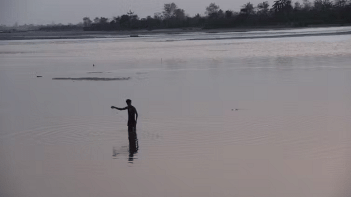 A fisher collects his net on a winter evening in the Subansiri. The river is calm and shallow in many places at that time of year, and people can walk across parts of the river. | Photo: Parag Saikia