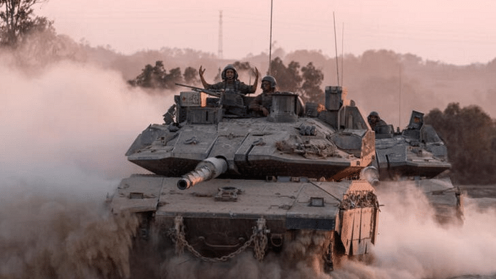 An Israeli soldier gestures on a top of a tank as Israeli military vehicles manoeuvre, near the Israel-Gaza border | File Photo | Reuters | Amir Cohen