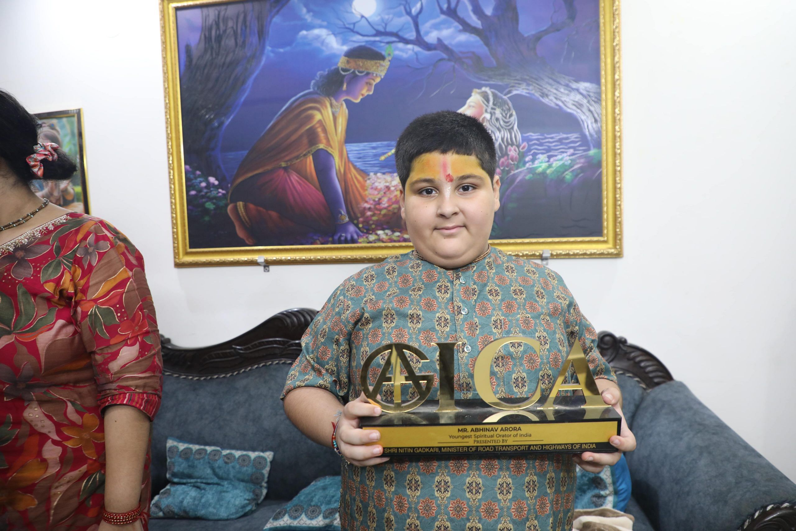 Arora in his living room with the Youngest Spiritual Orator award, his sister staying near him at all times