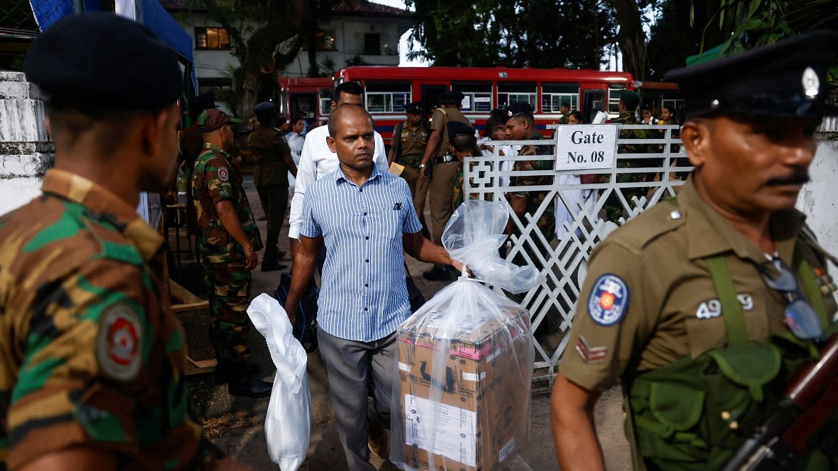 An election official carrying a ballot box walks at a counting centre in Colombo, Sri Lanka | REUTERS/Dinuka Liyanawatte