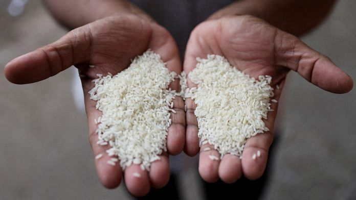 A man compares different grains of rice at a wholesale market in Navi Mumbai, India August 4, 2023. REUTERS/Francis Mascarenhas/File Photo