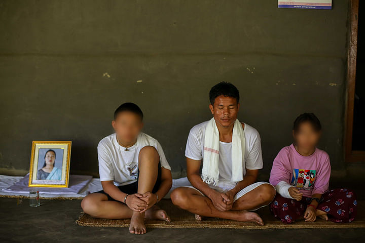 Rojiya, her father and brother sit next to a framed picture of Ngangbam Surbala | Suraj Singh Bisht | ThePrint