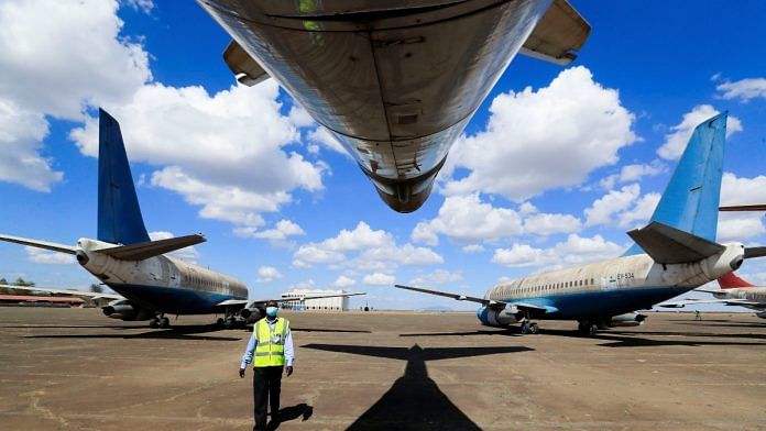 A Kenya Airports Authority worker inspects planes during an auction after previous owners abandoned them at the Jomo Kenyatta International Airport in Nairobi, Kenya, November 17, 2021. REUTERS/Thomas Mukoya/File Photo