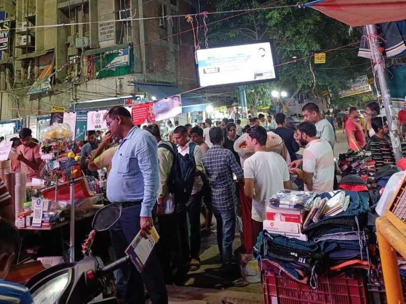 कुछ महीने पहले मुखर्जी नगर के बत्रा सिनेमा के बाहर एक व्यस्त शाम. सालों से यूपीएससी के उम्मीदवार यहां स्ट्रीट फूड खाने, एक-दूसरे से नोट्स का लेनदेन करने या अपनी कठोर दिनचर्या से ब्रेक लेने के लिए इकट्ठा होते हैं. अब यह रौनक कम होती जा रही है, क्योंकि कुछ प्रमुख कोचिंग संस्थान और छात्र यहां से दूर जा रहे हैं. फोटोः विशेष व्यवस्था द्वारा