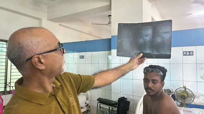 Professor Mohammad Abdul Quader, a cornea expert and the doctor on duty, examines the x-ray of Omar Farooq, 20. | Ananya Bhardwaj | ThePrint