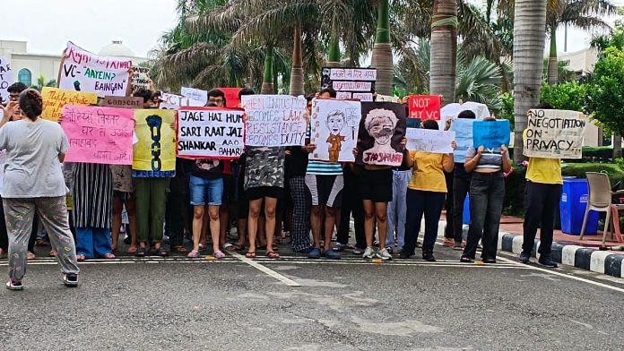 Students stand in front of RGNUL with posters demanding VC's resignation | Photo: Almina Khatoon, ThePrint