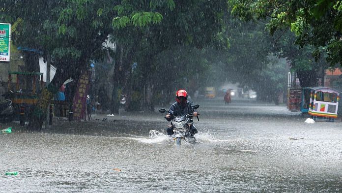 A man on a motorcycle wades through a flooded street amid heavy rainfall in Chennai on 15 October | Photo: ANI