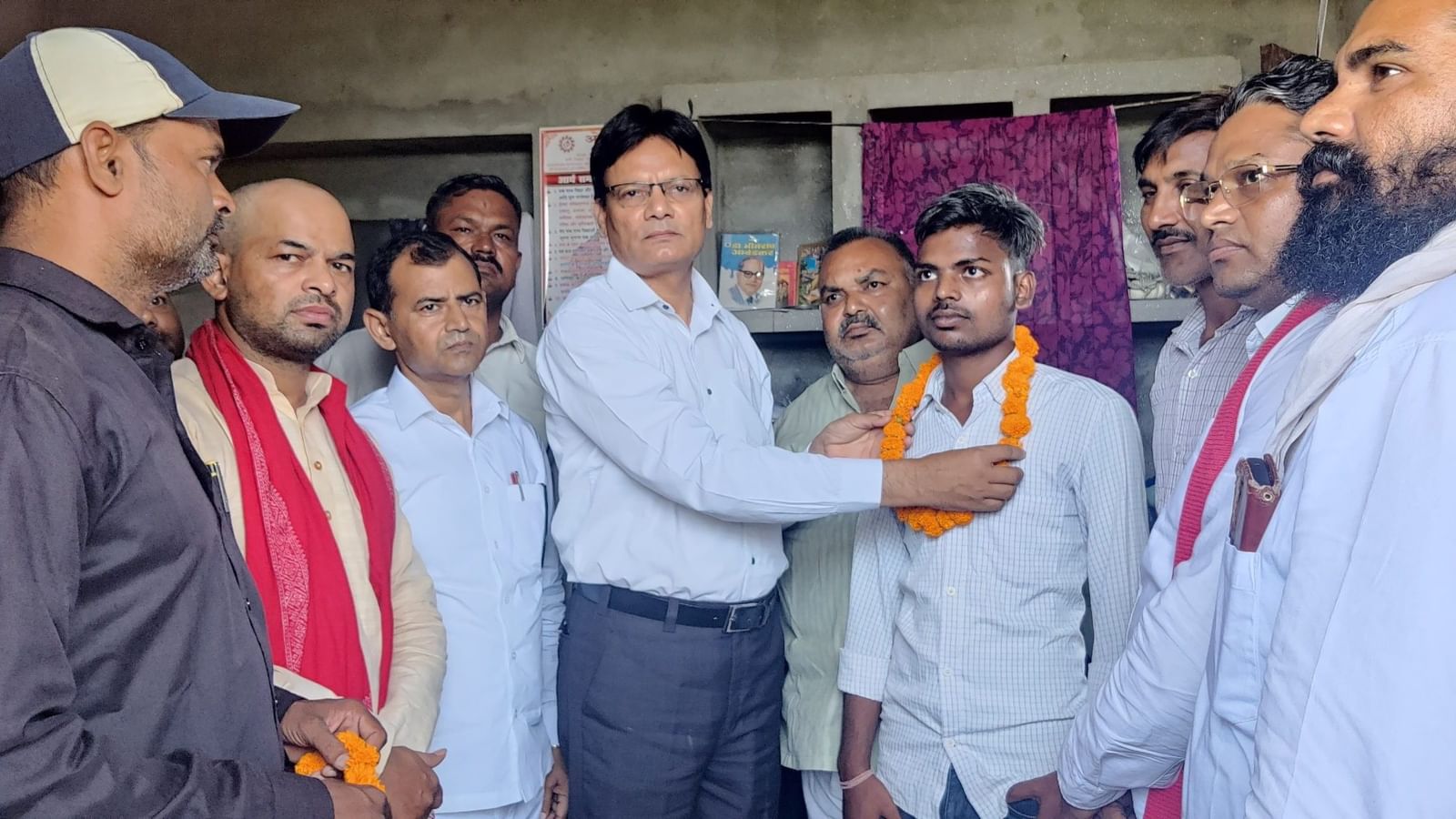 समाजवादी बाबासाहेब आंबेडकर वाहिनी (समाजवादी पार्टी का दलित मोर्चा) के एक समूह ने तीन महीने की कानूनी लड़ाई के दौरान उनके साहस और धैर्य के लिए अतुल और राजेंद्र को माला पहनाकर सम्मानित किया | फोटो: अलमिना खातून/दिप्रिंट