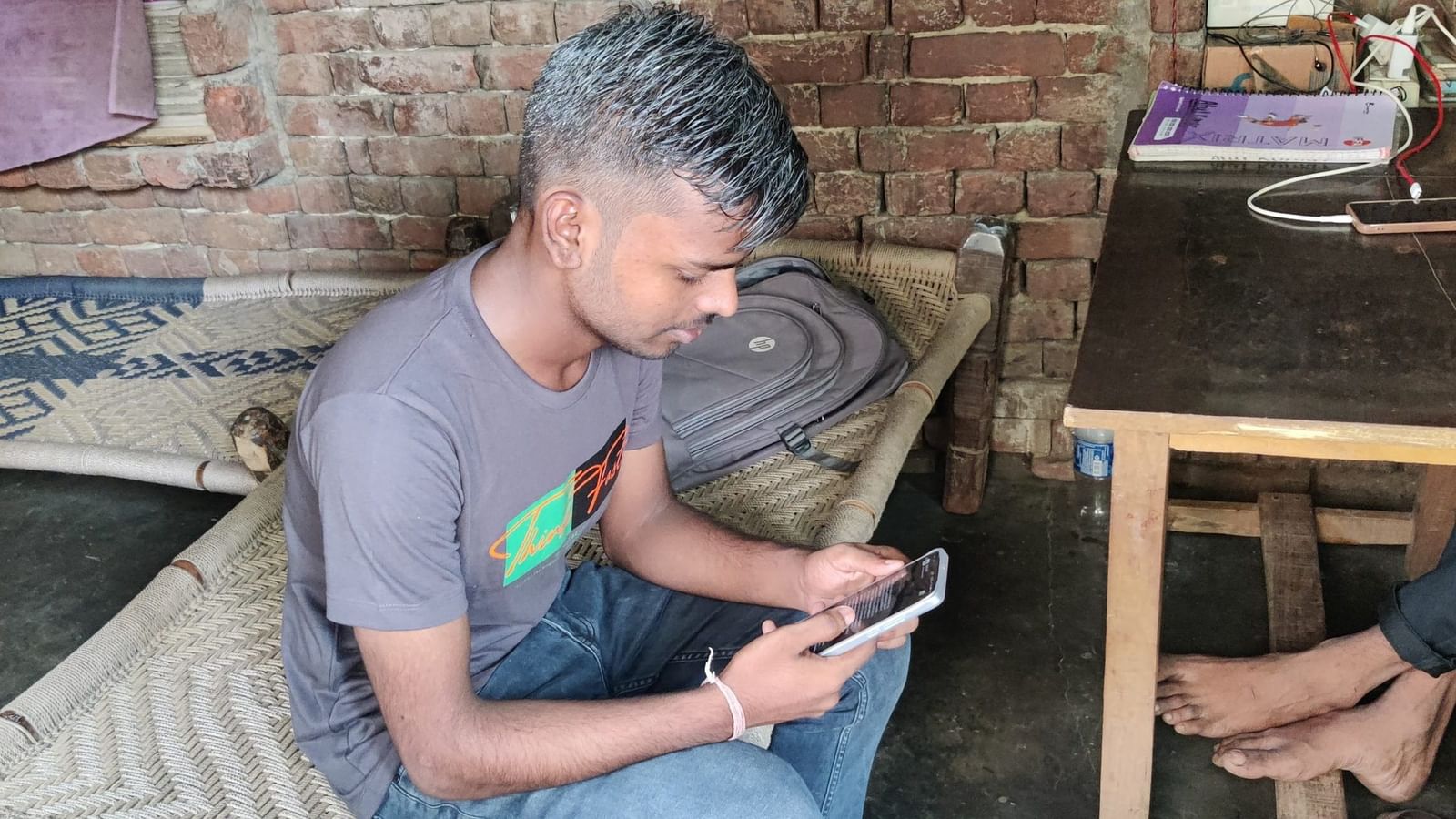 अतुल अपने नए खरीदे गए स्मार्टफोन को स्क्रॉल करते हुए | फोटो: अलमिना खातून/दिप्रिंट
