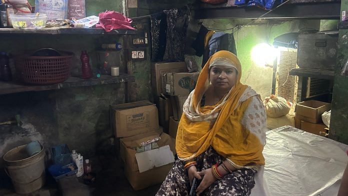 Asiya Bibi sits in a dark room consisting of a small bed and a makeshift kitchen | Zenaira Bakhsh | ThePrint