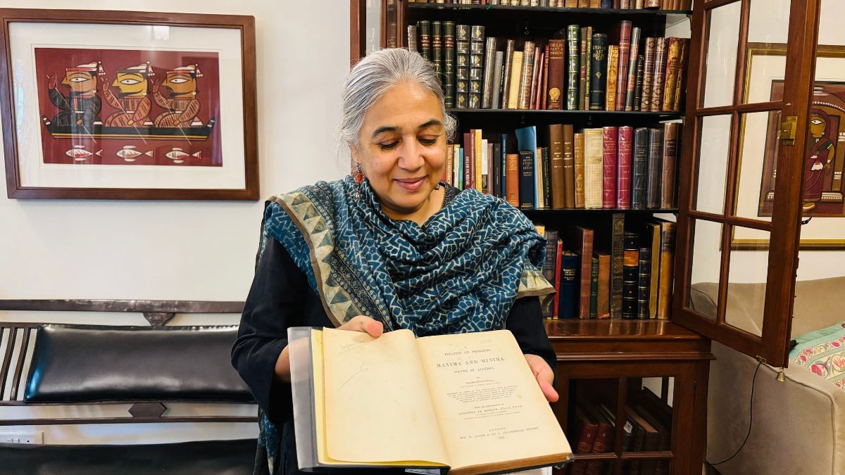 स्वप्ना लिडल, रामचंद्र की ‘मेक्सिमा और मिनिमा की समस्याओं पर ग्रंथ’ का पहला संस्करण प्रदर्शित करती हुई, जो कभी लुईस कैरोल के पास थी | फोटो: वंदना मेनन/दिप्रिंट