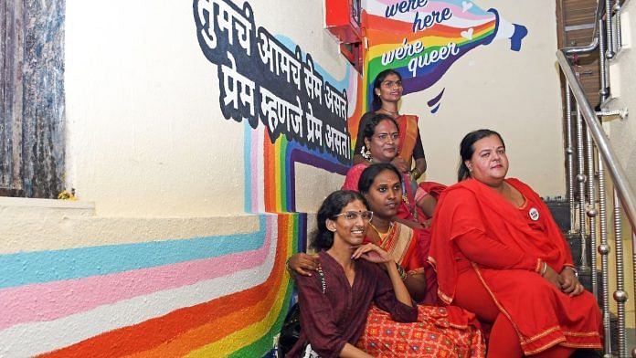 Members of the queer community watching news reports on Supreme Court's verdict on the marriage equality case