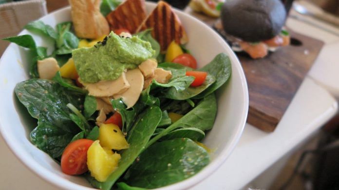 A salad bowl containing avocado and spinach, foods rich in zinc and magnesium.