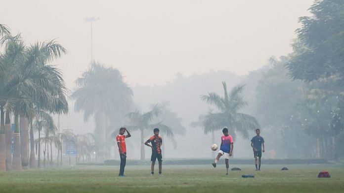 A group of boys play football on a lawn on a smoggy morning in New Delhi Thursday | REUTERS/Anushree Fadnavis