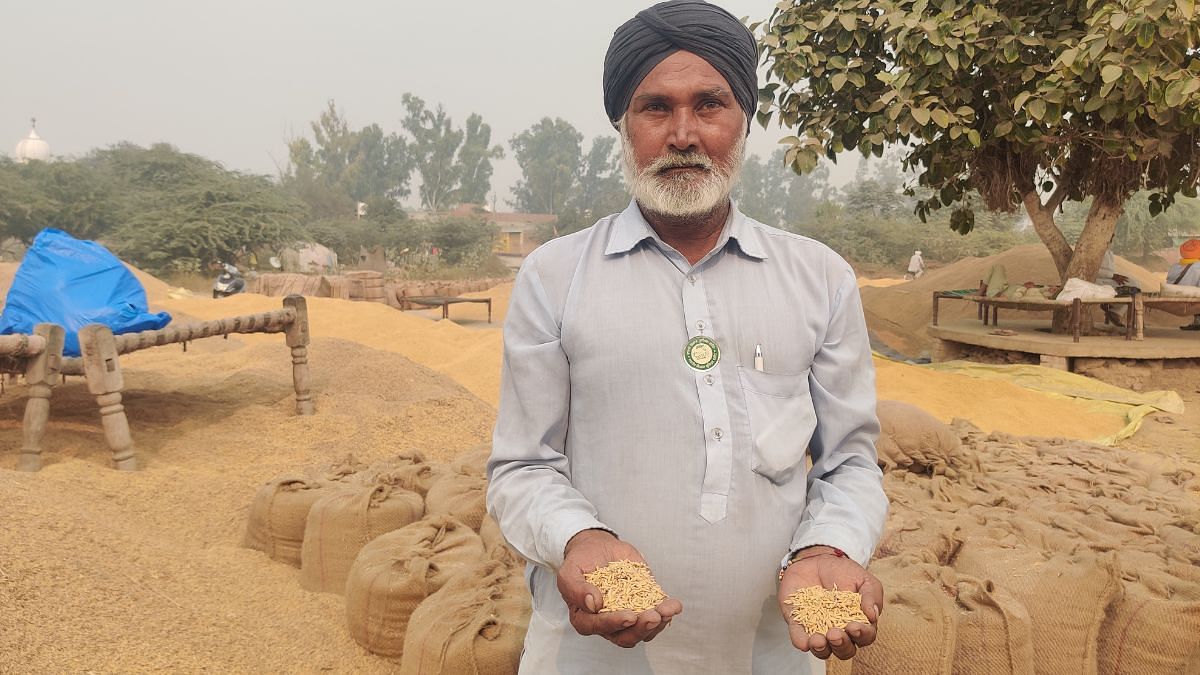 बिना बिके अपने धान का कुछ हिस्सा हाथ में पकड़े एक किसान | फोटो: शुभांगी मिश्रा/दिप्रिंट