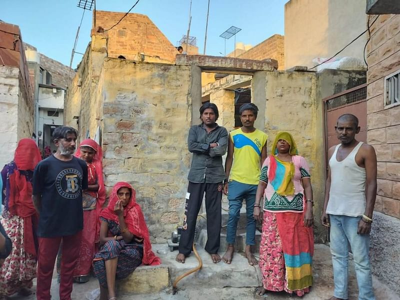जोधपुर के वाल्मीकि बस्ती में अपने परिवार के साथ बदली की कामगार पुष्पा. दशकों के काम के बावजूद, उन्हें कभी भी आधिकारिक नौकरी नहीं मिल पाई और उनके काम को रिकॉर्ड में न होने के कारण, सिफारिशी पत्र भी उनकी पहुंच से बाहर है | फोटो: शुभांगी मिश्रा/दिप्रिंट