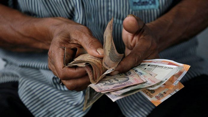 An attendant at a fuel station arranges Indian rupee notes in Kolkata, India | Rupak De Chowdhuri | Reuters