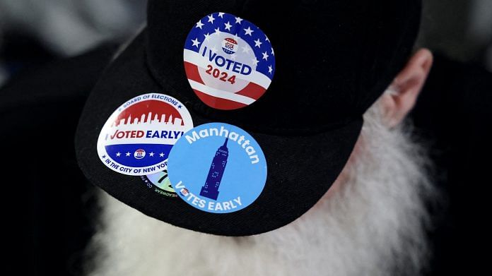 A man wears an hat with stickers, on Election Day for the 2024 U.S. presidential election in Manhattan, New York City, U.S. | Andrew Kelly | Reuters