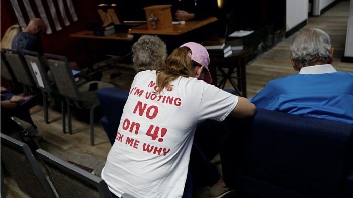 Ashley Urban, wearing a 'Vote No' on Florida Amendment 4 shirt, which addresses the state’s abortion bill, prays with other parishioners for an ‘Election Eve Service of Prayer,’ in support of Republican Presidential nominee and former U.S. President Donald Trump at Suncoast Liberty Fellowship in Largo, Florida, U.S. | Octavio Jones | Reuters