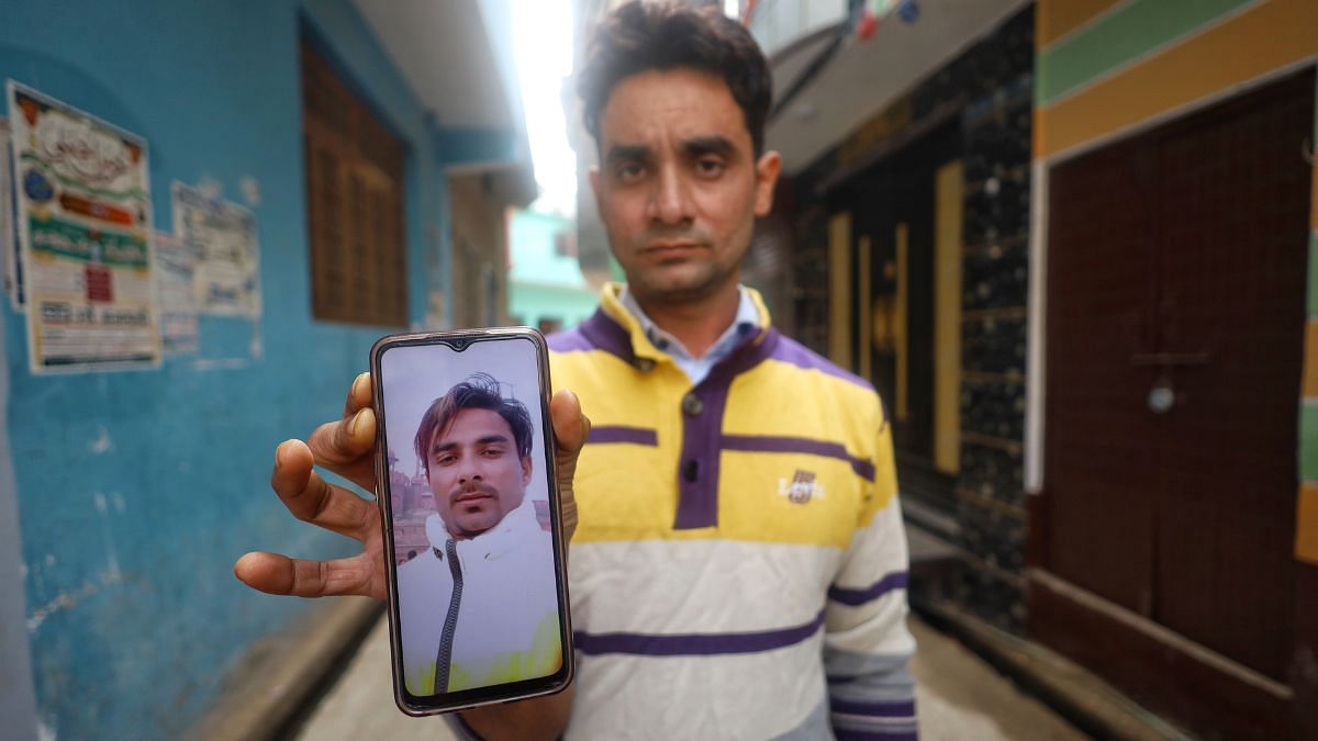 तस्लीम अपने भाई नईम की तस्वीर दिखाते हुए | फोटो: मनीषा मोंडल/ दिप्रिंट