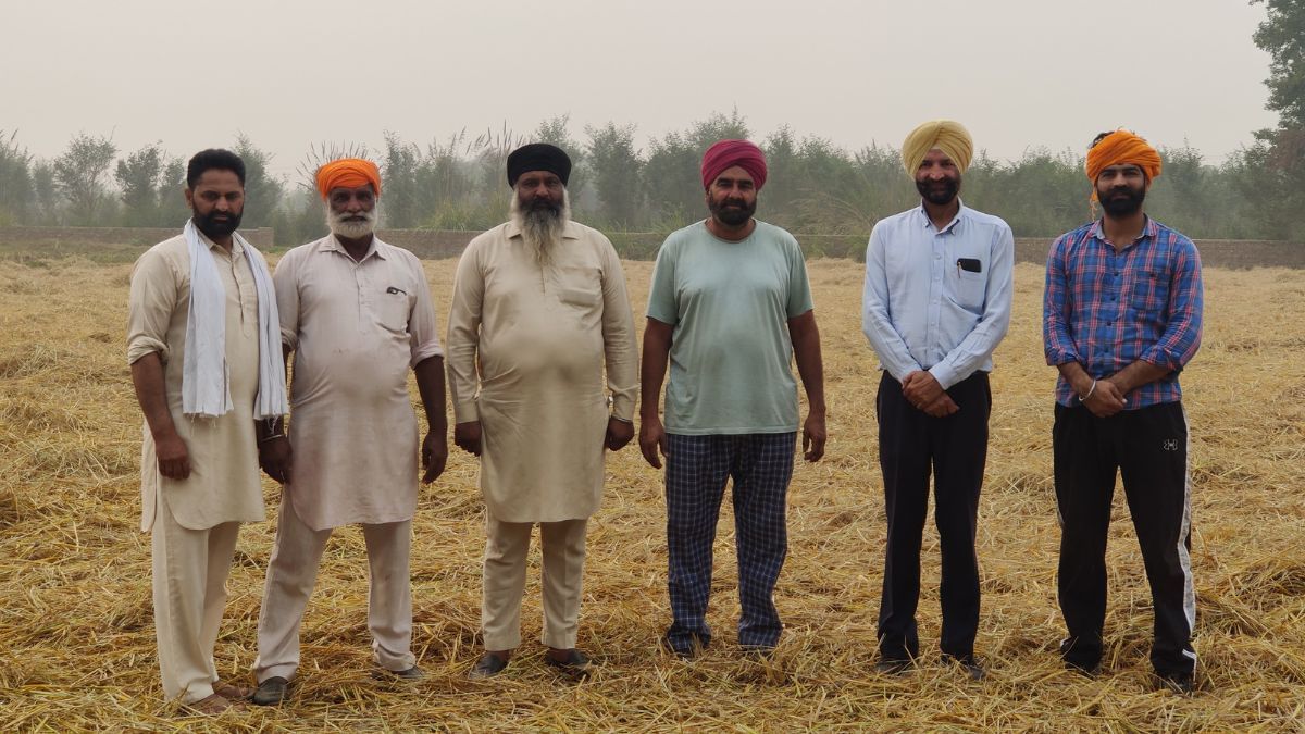 वेरका गांव के किसान कटे हुए धान के खेत के सामने | शुभांगी मिश्रा/दिप्रिंट