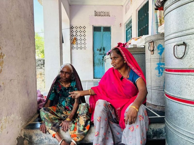 92-वर्षीय धापू देवी अपनी बहू संतोष के साथ बैठी हैं. राजस्थान के रिकॉर्ड में गलत तरीके से ‘मृत’ चिह्नित किए जाने के बाद वे अपनी पेंशन को फिर से शुरू करने के लिए संघर्ष कर रही हैं | फोटो: वंदना मेनन/दिप्रिंट