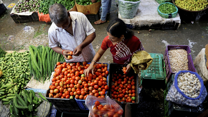 A woman selects tomatoes from a vegetable vendor, at a wholesale market in Navi Mumbai, India, 4 August 2023 | Francis Mascarenhas | Reuters