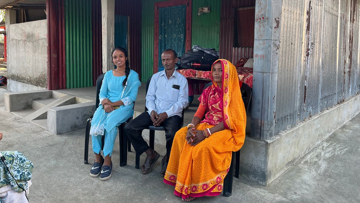 कबिता महतो का परिवार — उनकी बहन, पिता और मां — अपने घर के सामने बैठा है. यह घर उसने घर भेजे गए पैसों से बनवाया है | फोटो: नूतन शर्मा/दिप्रिंट