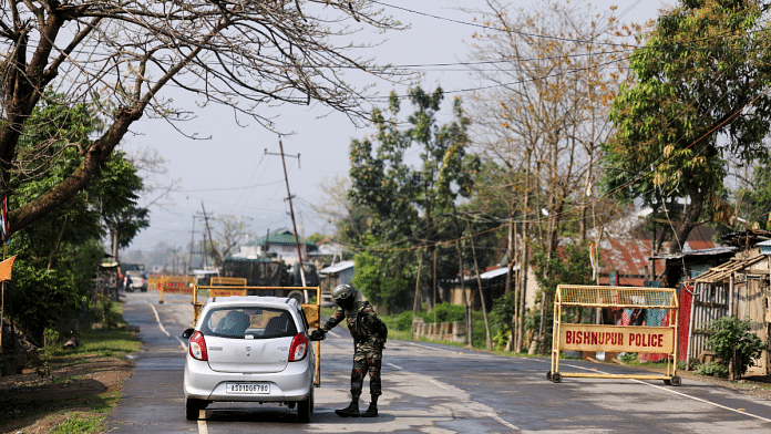An armed Kuki man stands at a checkpoint at Kangvai village in Churachandpur district in the northeastern state of Manipur, India, on 23 July 2023. | Adnan Abidi | Reuters