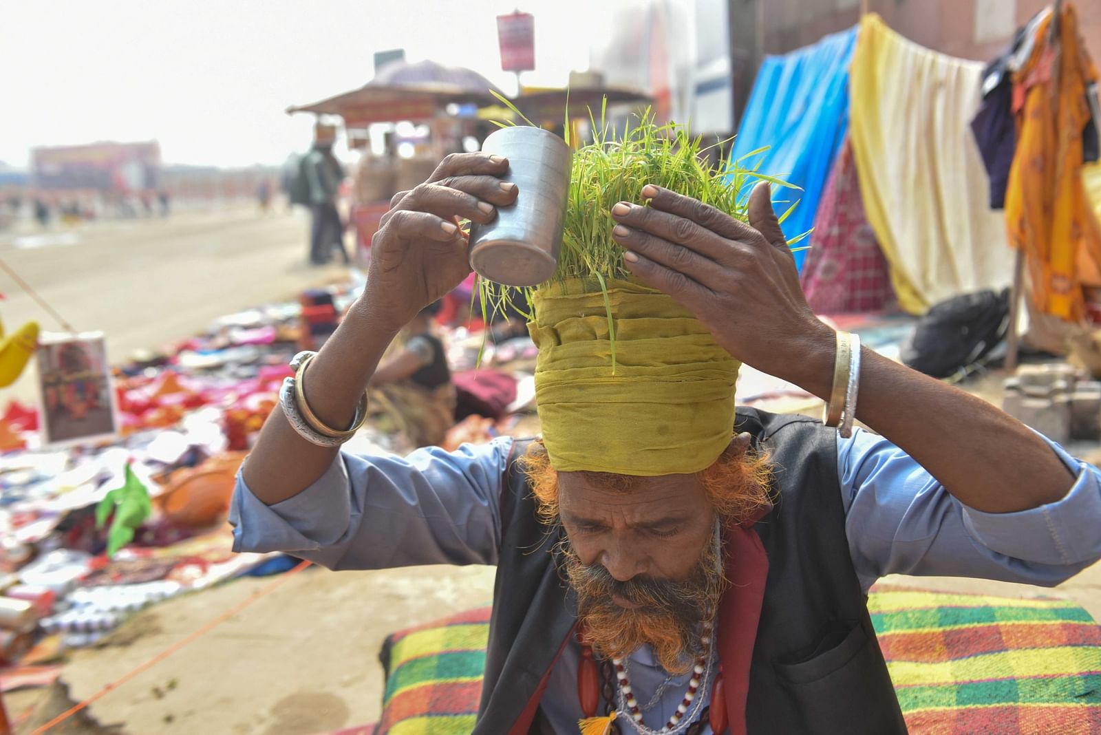 अनाज वाले बाबा अपनी ‘सिर की फसल’ को पानी देते हुए | फोटो: सूरज सिंह बिष्ट/दिप्रिंट