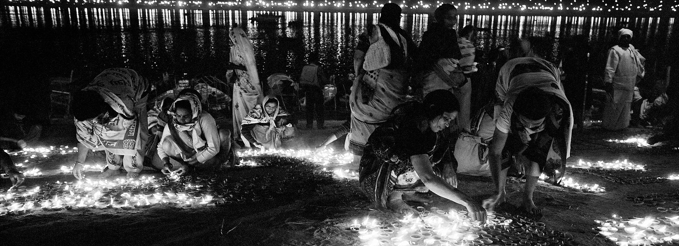 Ardh Kumbh Mela 2007: A group of women light diyas (earthern oil lamps) as an offering to the sacred rivers.
