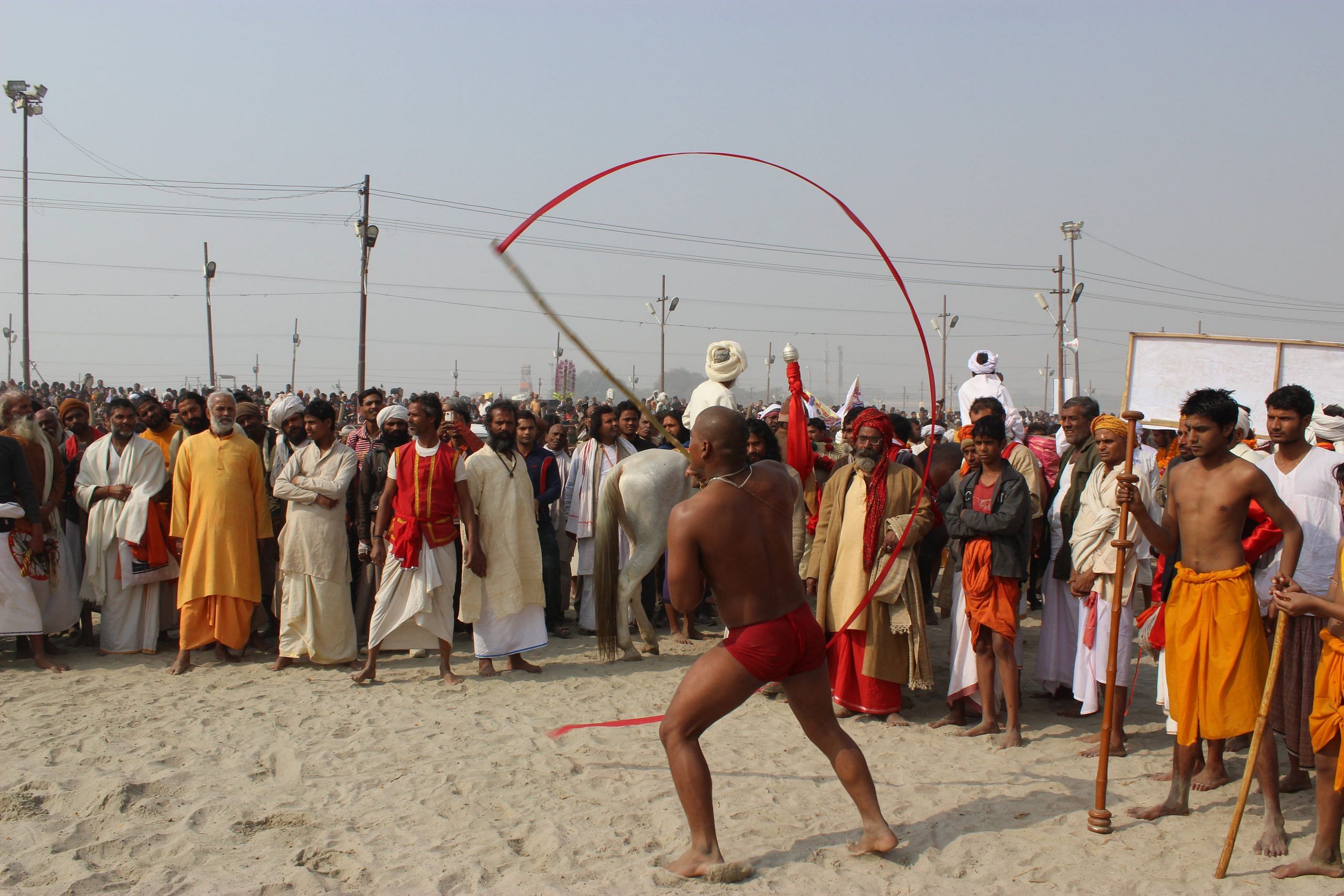 A monk from an akhara performing as devotees watch in awe 