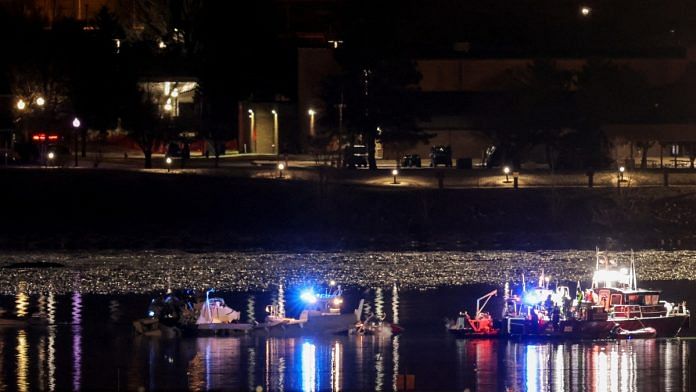Emergency personnel and divers work next to parts of the wreckage of the American Eagle flight 5342, after it collided with a Black Hawk helicopter while approaching Reagan Washington National Airport and crashed into the Potomac River, outside Washington