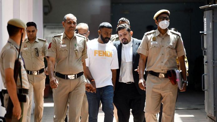 File photo of conman Sukesh Chandrashekhar (centre) in New Delhi. | ANI