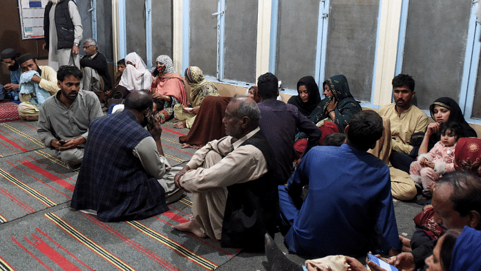 Passengers, who were rescued from a train after it was attacked by separatist militants, sit at the Mach Railway Station in Mach, Balochistan, Pakistan, March 11, 2025 | Reuters
