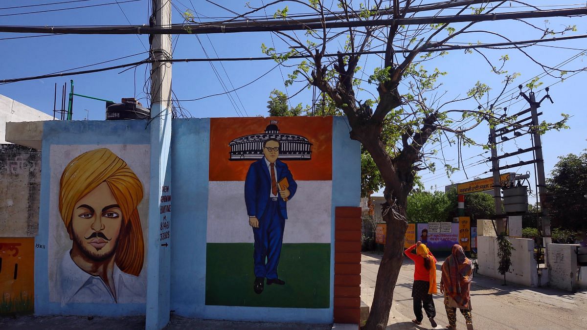ताजपुर गांव के प्रवेश द्वार पर आंबेडकर और भगत सिंह की तस्वीरें | फोटो: मनीषा मोंडल/दिप्रिंट
