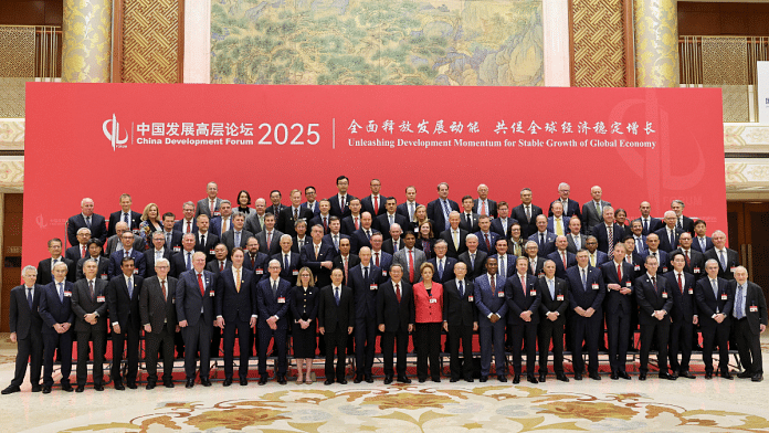 Chinese Premier Li Qiang poses for a family photo with attendees of the China Development Forum at Diaoyutai Guesthouse in Beijing, China March 23, 2025