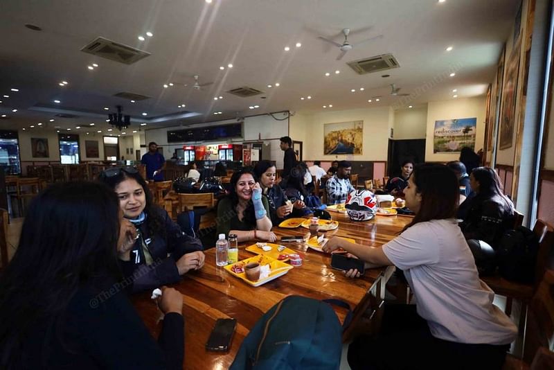 आगरा जाने वाले लेट्सराइड क्रू के मेंबर्स हाईवे पर नाश्ते के दौरान बातचीत करते हुए | फोटो: मनीषा मोंडल/दिप्रिंट