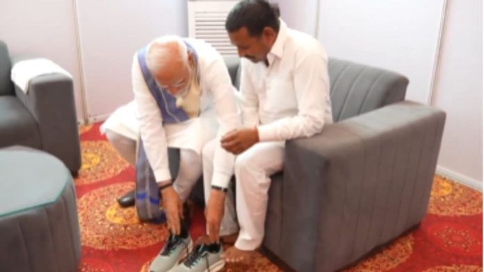 Prime Minister Narendra Modi helping Rampal Kashyap wear the sneakers he gifted the 57-year-old. | X/@narendramodi