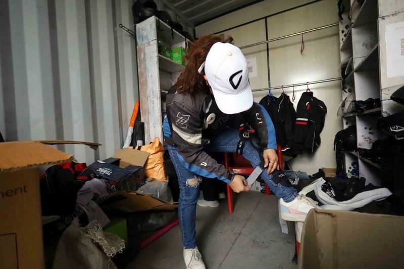 प्रैक्टिस ट्रैक पर जाने से पहले एक राइडर घुटने के गार्ड पहन रही हैं. ट्रेनिंग के दौरान भी सुरक्षा गियर से समझौता नहीं किया जा सकता है | फोटो: मनीषा मोंडल/दिप्रिंट