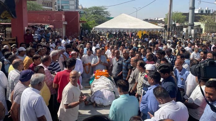 Neeraj Udhwani’s body garlanded outside the crematorium gates | Photo: Udit Hinduja | ThePrint