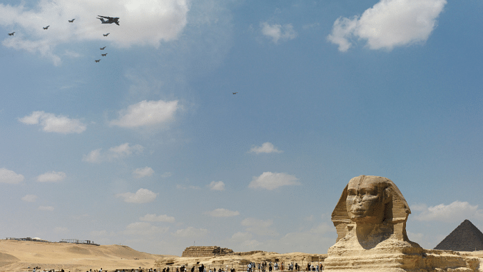 Military aircraft fly in formation, as tourists look on, at the Giza pyramid complex, as China and Egypt conduct their first joint air force exercise, in Giza, Egypt May 1, 2025 | File photo | Reuters