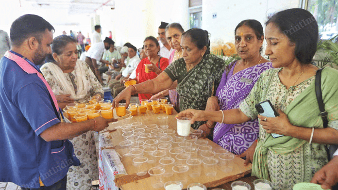 Krishna Ben Agrawal (purple sari) and women volunteers associated with a civil society group hand out glasses of mango shake, buttermilk for the people at Ahmedabad's BJ Medical College on Sunday | Praveen Jain | ThePrint