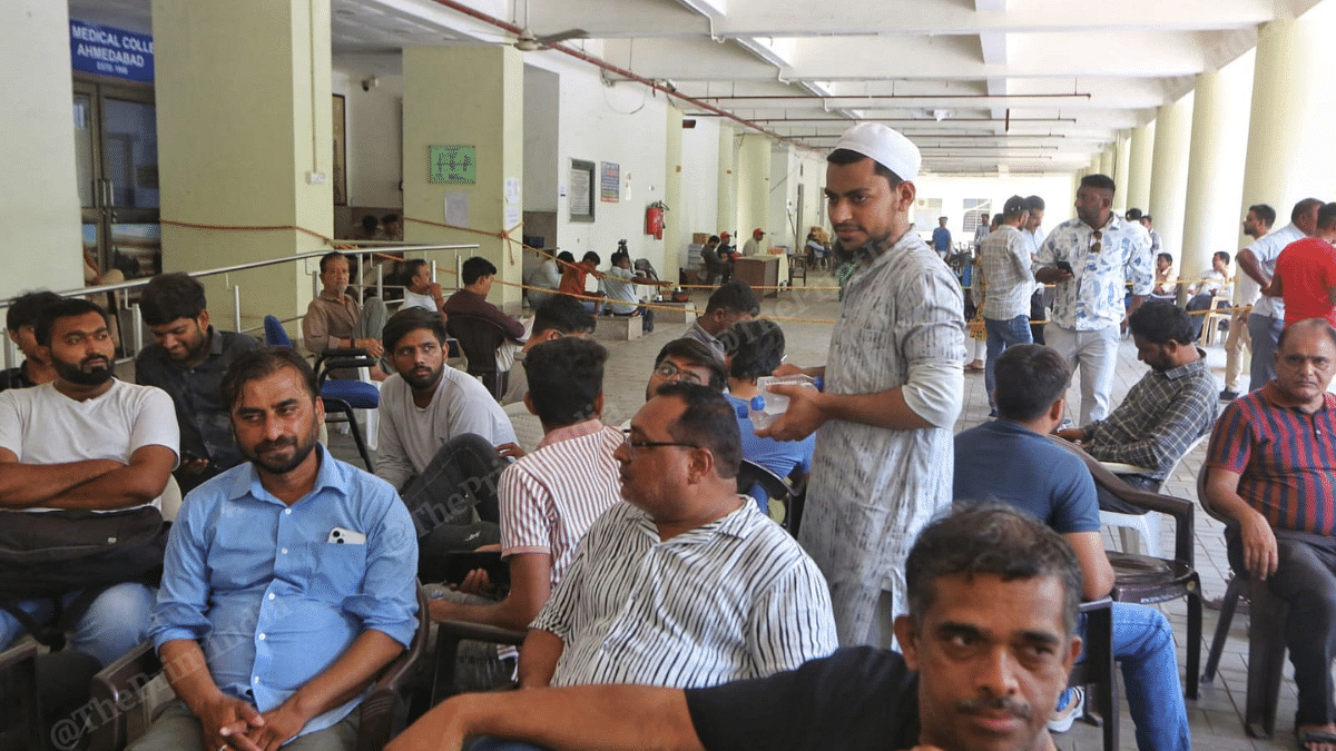 Hafiz Nizam (standing) of Jamiat Ulama-i-Hind serves refreshments to the people at Ahmedabad's BJ Medical College on Sunday | Praveen Jain | ThePrint 